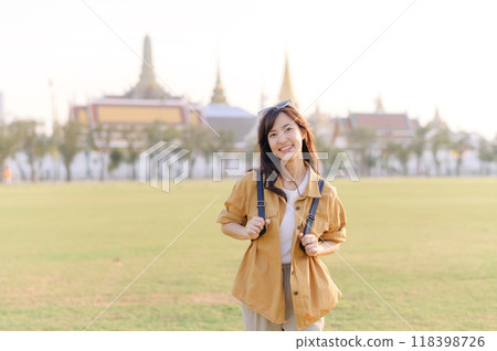 A Traveler Asian woman in her 30s exploring Wat Pra Kaew. From stunning architecture to friendly locals, she cherishes every moment, capturing it all in her heart and camera for years to come. 118398726