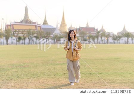 A Traveler Asian woman in her 30s exploring Wat Pra Kaew. From stunning architecture to friendly locals, she cherishes every moment, capturing it all in her heart and camera for years to come. 118398728