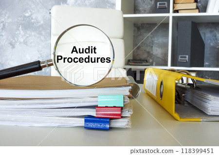 Magnifying glass with audit procedures text on documents. Financial scrutiny. 118399451