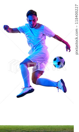 Focused football player, in training session, works on controlling ball with neon-lit background, demonstrating precision and athleticism. 118400227