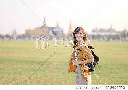 A Traveler Asian woman in her 30s exploring Wat Pra Kaew. From stunning architecture to friendly locals, she cherishes every moment, capturing it all in her heart and camera for years to come. 118400920