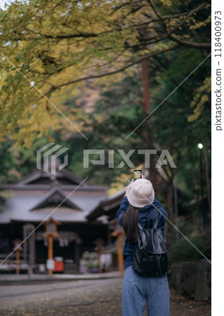 Asian woman explores Japanese shrines and temples, enjoying a holiday filled with smiles, spirituality, and the beauty of nature in Tokyo and Kyoto. 118400973