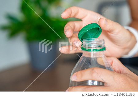 Stationary plastic cap on a PET bottle. The new design means the cap remains attached to the bottle after opening, making the entire package easier to collect and recycle 118401196