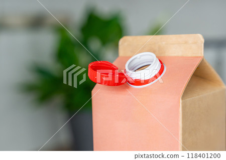 Long-life cardboard container from recycling materials with stationary plastic cap. Cap remains attached after opening, making the entire package easier to collect and recycle Long-life cardboard container from recycling materials with stationary plastic cap. Cap remains attached after opening, making the entire package easier to collect and recycle 118401200