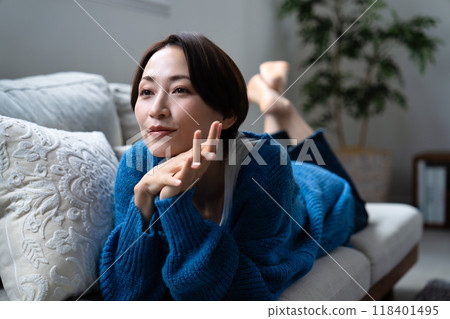 中年婦女放鬆地躺在沙發上 中年婦女放鬆地躺在沙發上 118401495