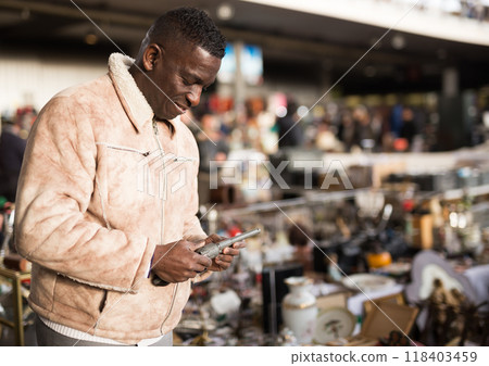 Man chooses antiques on the flea market Man chooses antiques on the flea market 118403459
