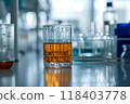 Amber-tinted lab glass in atmospheric, slightly blurred laboratory 118403778