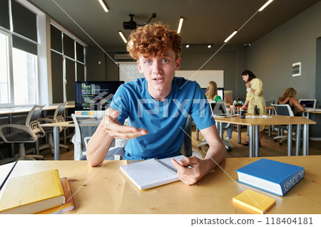 POV of red haired young man gesturing and looking at camera while talking to video chat in school POV of red haired young man gesturing and looking at camera while talking to video chat in school 118404181