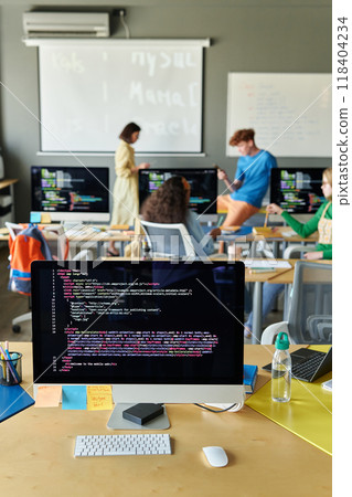 Vertical background image of classroom with computer on desk in IT class in school and code lines on screen 118404234