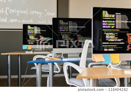 Background image of modern computer classroom with desks in row and code lines on PC screens, copy space 118404282