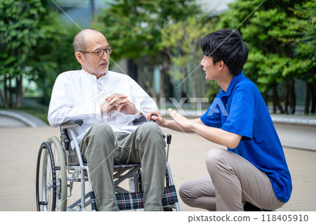 Senior man in wheelchair and care facility staff 118405910