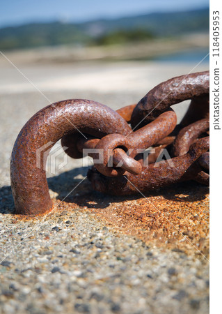 Rusty chain attached to an anchor attached to a dike 118405953