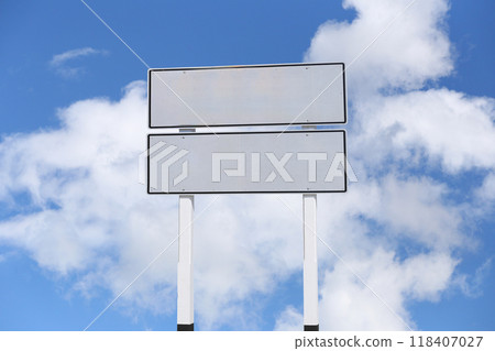 Empty white sign with a background of a blue sky and white clouds. 118407027