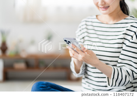 一名年輕女子正在操作智慧型手機。 (部分) 一名年輕女子正在操作智慧型手機。 (部分) 118407172