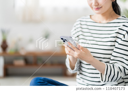 一名年輕女子正在操作智慧型手機。 (部分) 一名年輕女子正在操作智慧型手機。 (部分) 118407173