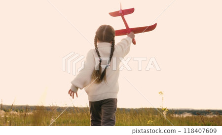 Child with toy airplane runs across field. Little kid imagines to be pilot, playing game, dreaming of great future. Concept of children's dreams, vivid imagination and active play. Rear back view. Child with toy airplane runs across field. Little kid imagines to be pilot, playing game, dreaming of great future. Concept of children's dreams, vivid imagination and active play. Rear back view. 118407609