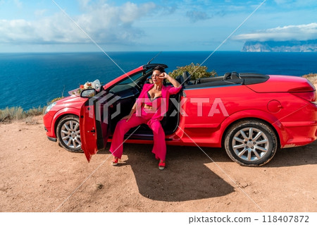 A woman is sitting in the back of a red convertible car A woman is sitting in the back of a red convertible car 118407872