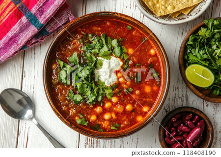 Traditional mexican red pozole in bowl on white wooden table 118408190