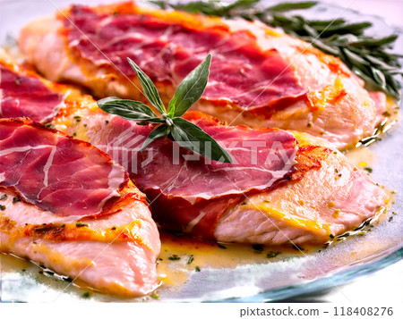 Chicken Saltimbocca with prosciutto and sage served on a transparent glass plate flavorful and tender Chicken Saltimbocca with prosciutto and sage served on a transparent glass plate flavorful and tender 118408276