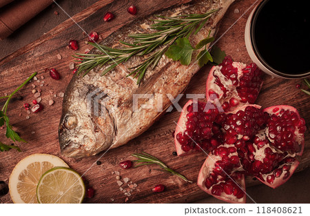 Fried dorado fish, with spices and herbs, on a wooden board, pomegranate sauce, close-up, no people, Fried dorado fish, with spices and herbs, on a wooden board, pomegranate sauce, close-up, no people, 118408621