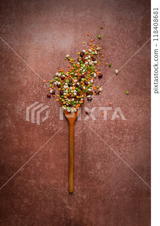 wooden spoon, with an assortment of legumes, beans, peas, top view, on a brown background, 118408681