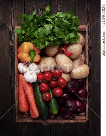 Assortment of vegetables, in a wooden food box, on a wooden table, top view, no people 118408828