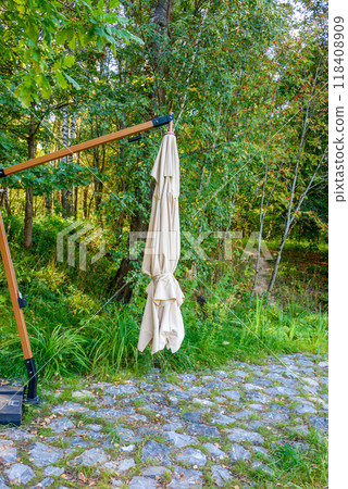 Ecological walking path made of cobblestones and a folded beach umbrella for relaxation. 118408909