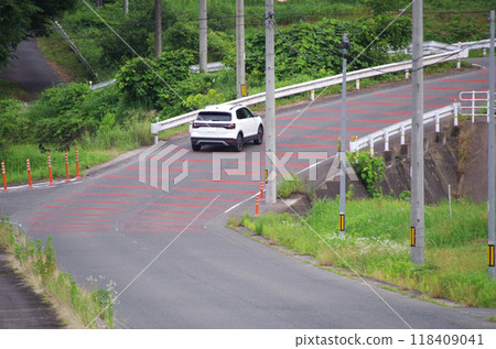 A steep, curving paved road that climbs the mountain slope 118409041