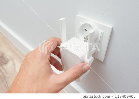 Wireless Wi-Fi repeater on white wall indoors 118409403