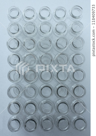 New glass vials for instrumental analysis on a white background. analytical vials prepared for chemical analysis New glass vials for instrumental analysis on a white background. analytical vials prepared for chemical analysis 118409733