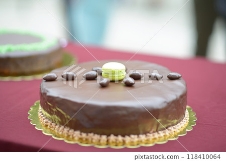 Chocolate Cake with Glossy Glaze, Green Macaron, and Chocolate Almonds Chocolate Cake with Glossy Glaze, Green Macaron, and Chocolate Almonds 118410064