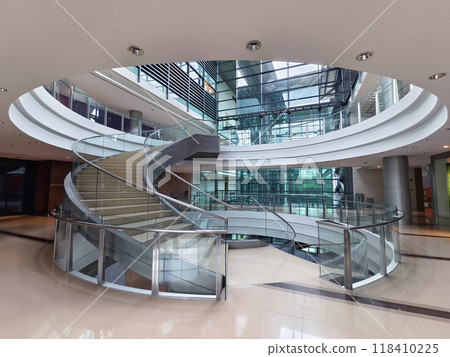 A beautifully designed spiral staircase in a modern building with glass railing 118410225