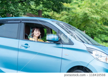 A woman driving a car A woman sitting in the driver's seat of a car 118410508