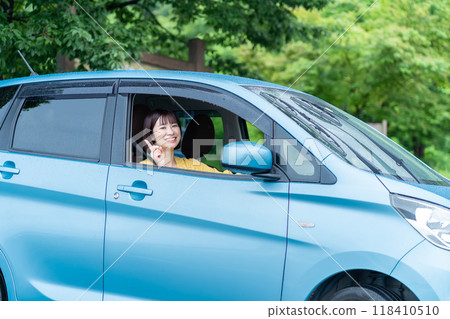 A woman driving a car A woman sitting in the driver's seat of a car A woman driving a car A woman sitting in the driver's seat of a car 118410510