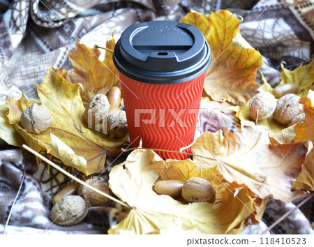 glass with a hot drink: coffee, cocoa or tea on yellow leaves glass with a hot drink: coffee, cocoa or tea on yellow leaves 118410523