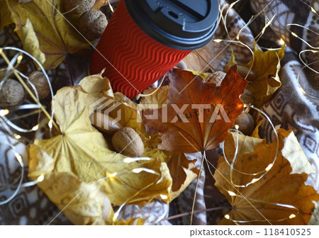 glass with a hot drink: coffee, cocoa or tea on yellow leaves glass with a hot drink: coffee, cocoa or tea on yellow leaves 118410525