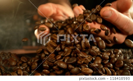 Man hands throwing roasted coffee beans. Man hands throwing roasted coffee beans. 118410593