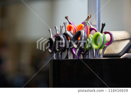 Colorful hair cutting scissors organized in a salon display at midday Colorful hair cutting scissors organized in a salon display at midday 118410839