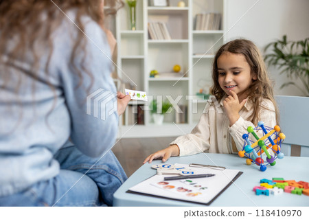 Female speech therapist having a training session with a long-haired girl 118410970