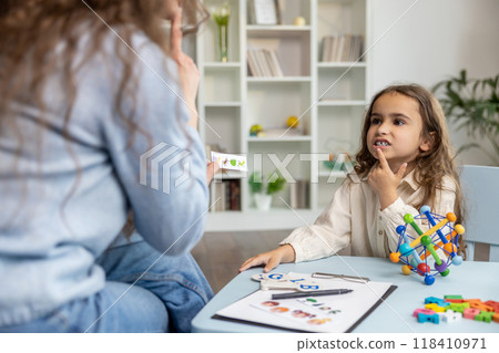 Female speech therapist having a training session with a long-haired girl 118410971