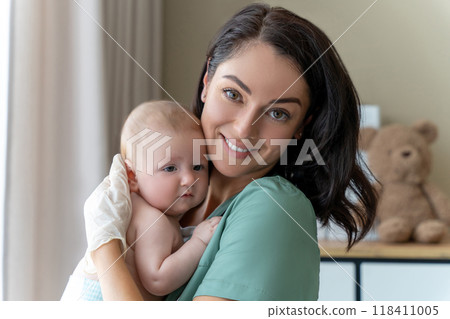 Beautiful nurse medical worker in gloves holding newborn baby in hands Beautiful nurse medical worker in gloves holding newborn baby in hands 118411005