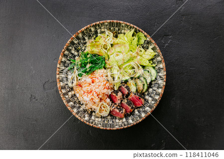 Healthy poke bowl with seared tuna, rice, seaweed salad, fresh vegetables - vibrant and nutritious 118411046