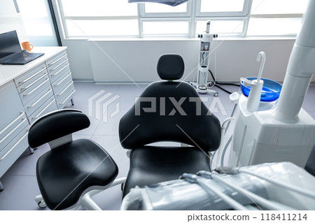 Modern dental clinic with advanced technology and clean equipment featuring an empty orthodontic chair Modern dental clinic with advanced technology and clean equipment featuring an empty orthodontic chair 118411214