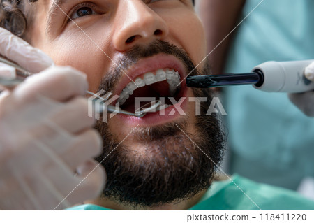 Doctor in clinic conducting detailed tooth inspection Doctor in clinic conducting detailed tooth inspection 118411220