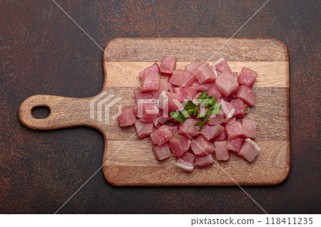 Pieces of raw pork meat on wooden cutting board with knife top view Pieces of raw pork meat on wooden cutting board with knife top view 118411235