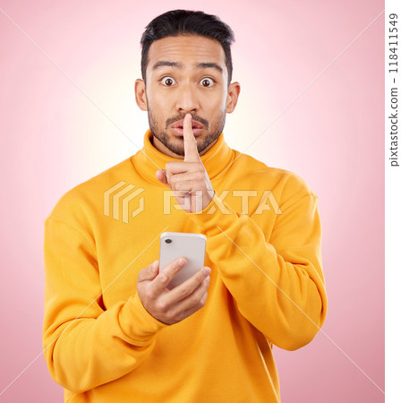 Man, phone and studio with finger, silence and sign language for secret promotion by pink background. Gen z guy, student or fashion model with smartphone, hand and lips for portrait, deal and sale Man, phone and studio with finger, silence and sign language for secret promotion by pink background. Gen z guy, student or fashion model with smartphone, hand and lips for portrait, deal and sale 118411549