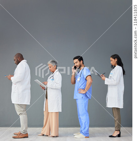 Doctors standing in a row isolated on wall background with tablet, phone call and medical paperwork for hospital. Healthcare people or nurse technology in waiting room for clinic or hiring research 118411835