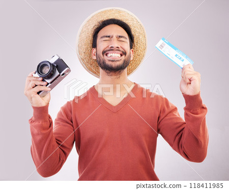 Ticket, camera and excited man in studio with paperwork for holiday, adventure and fun hat on white background. Smile, travel and happy person with boarding pass for vacation, journey and happiness. 118411985