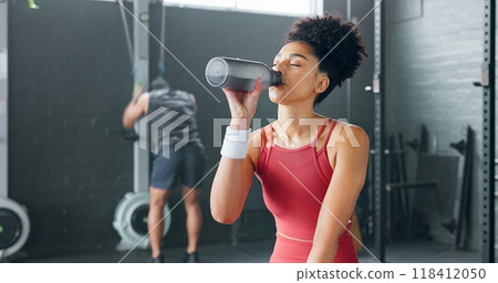 Woman, fitness and drinking water on break at gym after workout, training or indoor exercise. Active or sporty female person with mineral drink in rest for diet, natural nutrition or sustainability Woman, fitness and drinking water on break at gym after workout, training or indoor exercise. Active or sporty female person with mineral drink in rest for diet, natural nutrition or sustainability 118412050