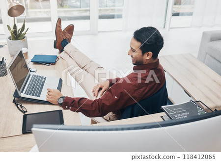 Working from home man with feet up on desk reading news on laptop with job confidence, productivity and online career. Remote worker, entrepreneur or professional person relax and smiling on computer Working from home man with feet up on desk reading news on laptop with job confidence, productivity and online career. Remote worker, entrepreneur or professional person relax and smiling on computer 118412065